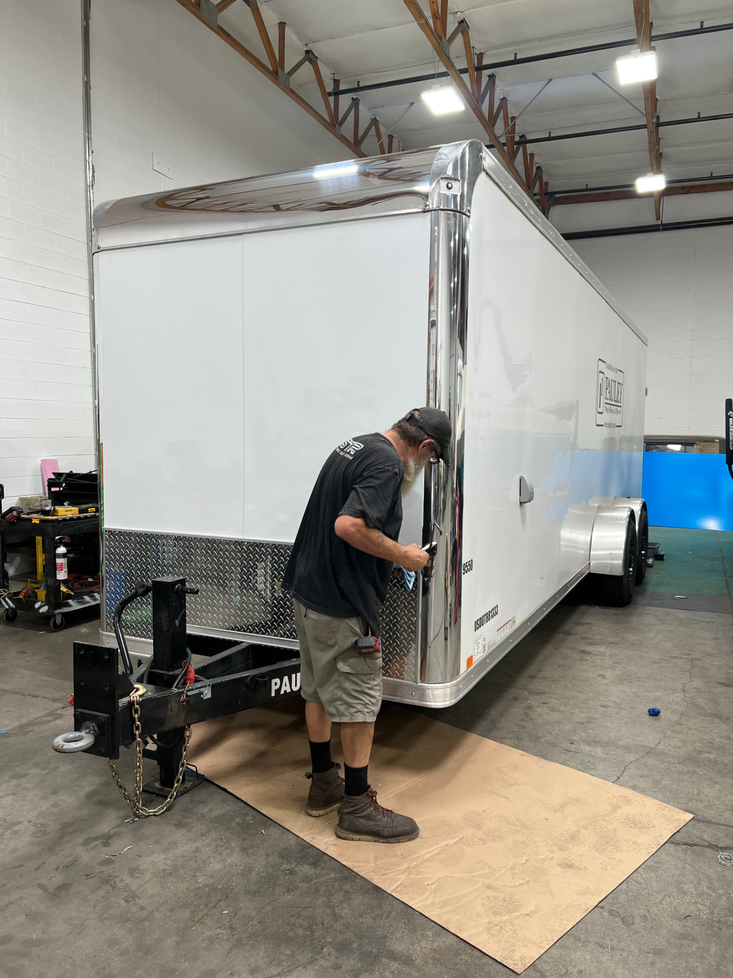 SPARKS technician servicing a white enclosed cargo trailer in the Gilbert, AZ shop